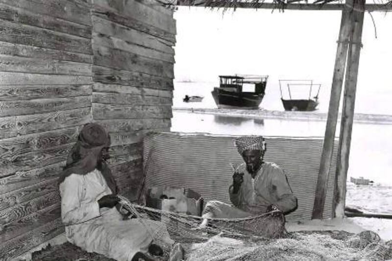 1979 Two fishermen repair their nets on the beach at Abu Dhabi not far from the Hilton Hotel and the Hiltonia Beach Club