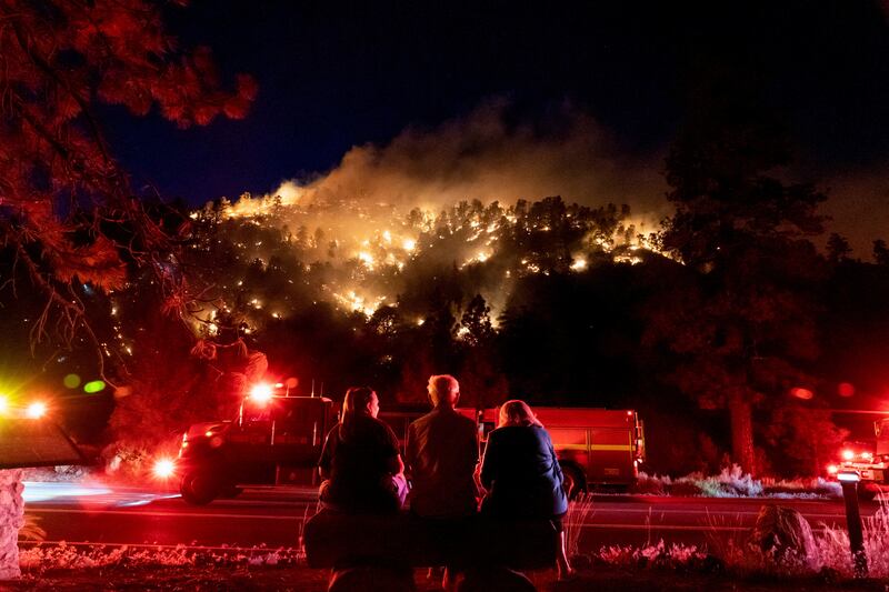 Residents watch part of the Sheep Fire wildfire burn through a forest on a hillside near their homes in Wrightwood, California. Reuters