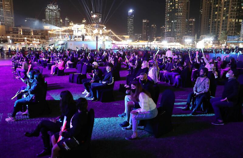 DUBAI , UNITED ARAB EMIRATES , December 18 – 2020 :- People sitting on the chair and enjoying the performance of Anne Marie at the Burj Park in downtown Dubai on the second day of the DSF opening concert in Dubai.  ( Pawan Singh / The National ) For Arts & Culture/Online/Instagram. Story by Janice Rodrigues