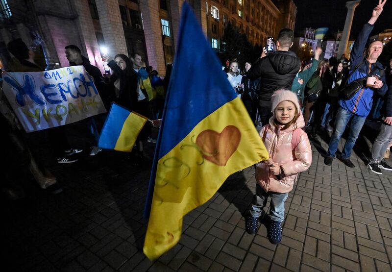 A child holds a Ukranian flag as people gather in Maidan square to celebrate the liberation of Kherson. AFP