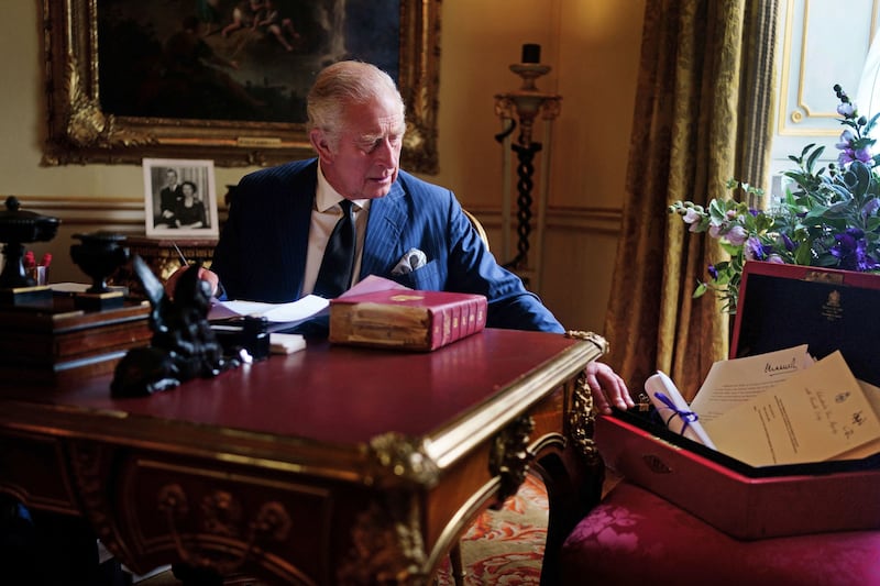 A picture shows King Charles III carrying out official government duties from his red box in the Eighteenth Century Room at Buckingham Palace, London. AFP