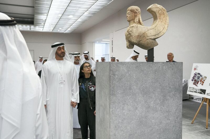 SAADIYAT ISLAND, ABU DHABI, UNITED ARAB EMIRATES - September 11, 2017: HH Sheikh Mohamed bin Zayed Al Nahyan, Crown Prince of Abu Dhabi and Deputy Supreme Commander of the UAE Armed Forces (L), and Alia Al Mansoori (C), look at the Archaic Sphinx while touring the newly constructed Louvre Abu Dhabi. 
( Ryan Carter / Crown Prince Court - Abu Dhabi )
---