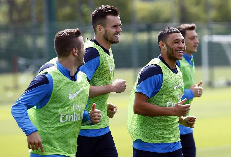 Arsenal midfielder Jack Wilshere, left, defender Carl Jenkinson, second left, forward Alex Oxlade-Chamberlain, second right, and midfielder Mesut Ozil, right, take part in Wednesday's training session ahead of the FA Cup final. Carl Court / AFP / May 14, 2014