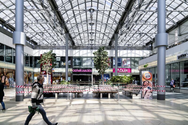 A pedestrian wearing a protective face mask passes a cordoned off seating area inside the Rathaus Galerie shopping mall in Essen, Germany, on Wednesday, April 15, 2020. Germany is poised to agree on an extension of most restrictions on public life into next month, underlining how European governments are struggling to balance reactivating their economies against fears of a resurgence of the coronavirus. Photographer: Wolfram Schroll/Bloomberg