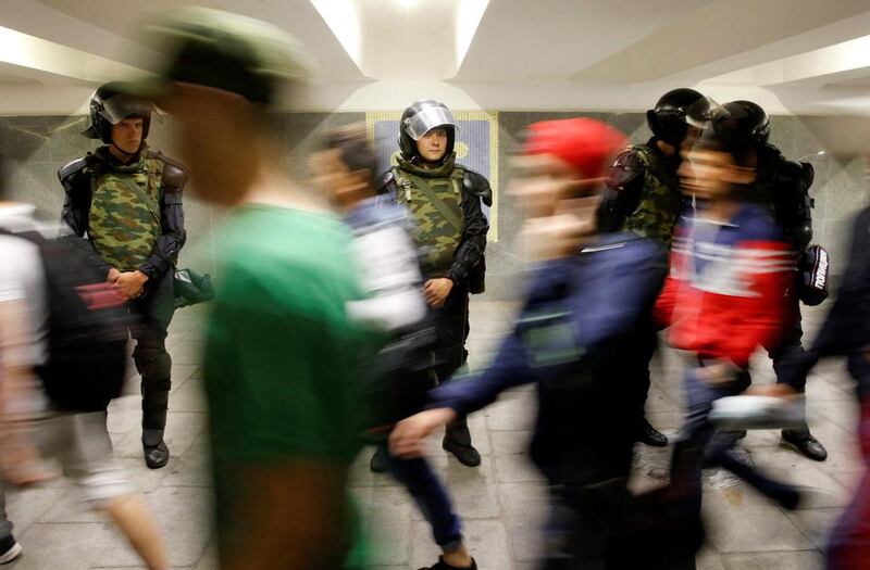 People pass by Interior Ministry members in an underground walkway before a morning prayer, in Moscow, Russia, July 5, 2016. Reuters