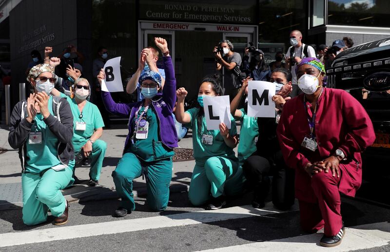 NYU Langone Health workers kneel and raise their fists in Manhattan, New York City. Reuters