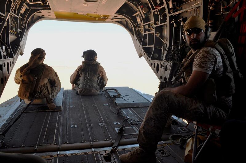 Emirati soldiers stand guard out the rear gate of a Chinook military helicopter travelling from Saudi Arabia to Yemen. AP Photo