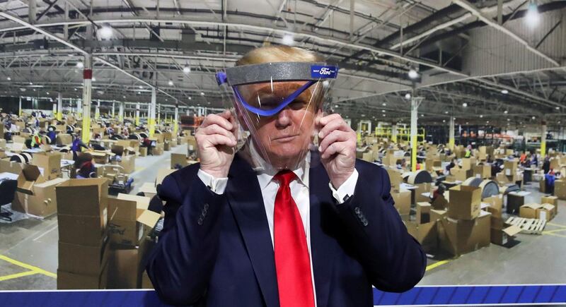 US President Donald Trump holds up a protective face shield during a tour of the Ford Rawsonville Components PlaNT in Ypsilanti, Michigan. REUTERS