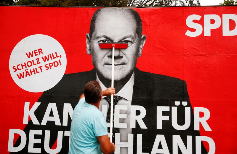 A poster of Olaf Scholz is placed on a board in Bonn. Photo: Reuters