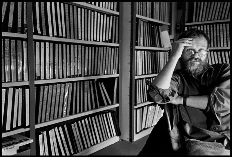FRANCE. Paris. 1985. Magnum Photos offices. Czech photographer Josef KOUDELKA, by the books holding his contact sheets.
