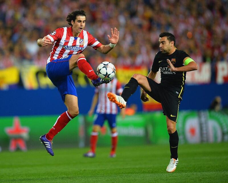 Tiago Mendes of Atletico Madrid controls the ball under pressure from Xavi of FC Barcelona during their Champions League match on Wednesday. Laurence Griffiths / Getty Images / April 9, 2014
