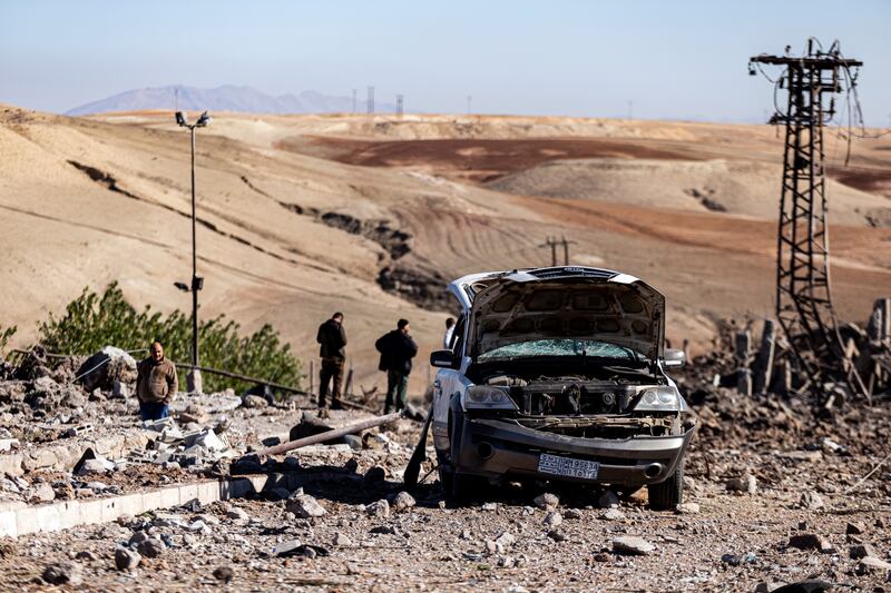 People inspect the damage after Turkish air strikes hit a power station in Taql Baql, Syria. AP