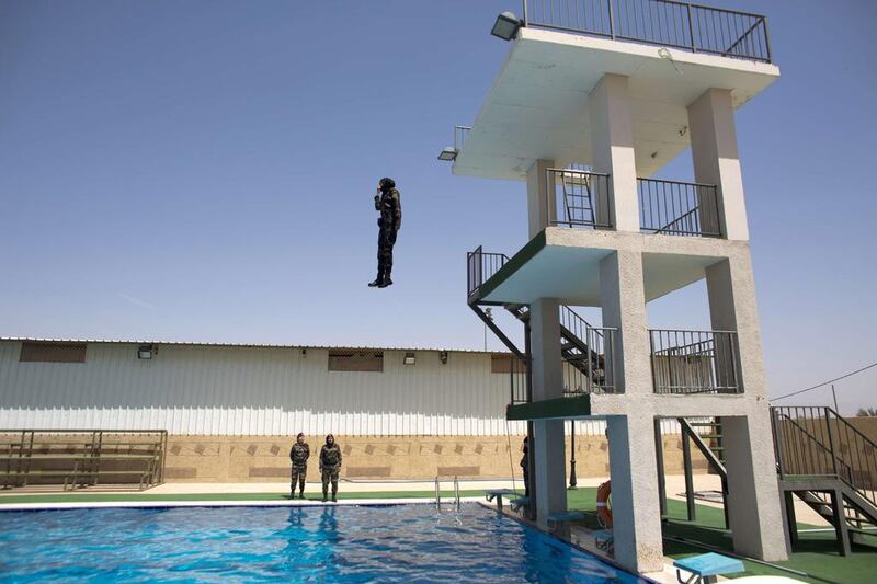 Several women, including non-swimmers, were asked to jump into a pool as a show of courage during the training exercise. They dived in full uniform, including boots, and one had to be pulled out by a lifeguard. Ahmad Gharabli / AFP