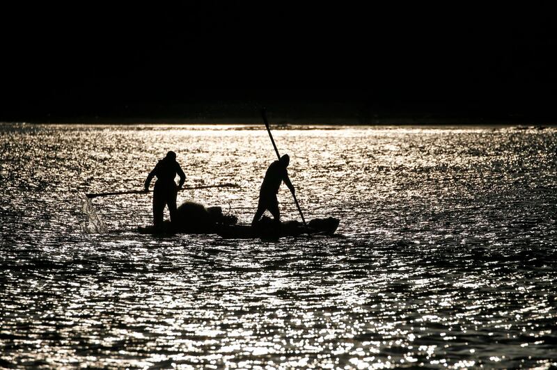 Palestinian fishermen row a boat after catching fish in the Mediterranean sea off Gaza City at sunrise.  AFP
