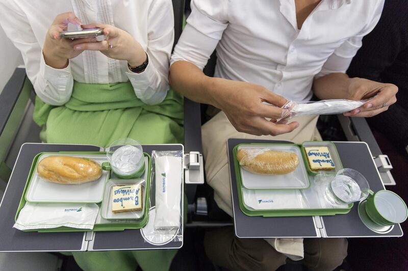 A passenger, left, uses a smartphone to take a photograph of an in-flight meal served on board an Airbus SE A321 Neo aircraft, operated by FLC Group JSC's Bamboo Airways, on the first day of the airline's operations during a flight from Hanoi to Qui Nhon, Vietnam, on Wednesday, Jan. 16, 2019. The International Air Transport Association forecasts Vietnam will be among the world’s top five fastest-growing air travel markets in the next 20 years. Photographer: Maika Elan/Bloomberg