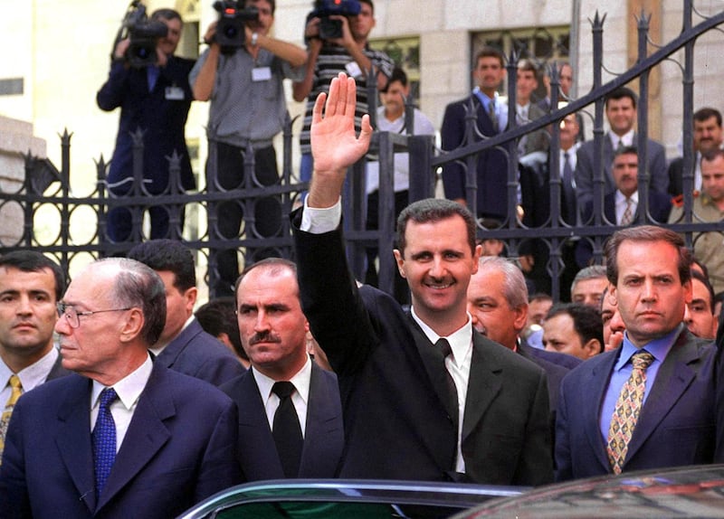 (FILES) A file photo taken on July 17, 2000 shows Syria's new President Bashar al-Assad (C) waving to supporters outside the parliament in Damascus 17 July 2000, after taking the oath of office. Bashar al-Assad's rise to power after three decades of his father's iron-fisted rule raised hope of democratic opening. But 20 years later, Syria is isolated and war-ravaged. Crumbling under a stinging economic downturn, Western sanctions and nine years of war, Syria today is a far cry from the vision Assad projected when he was propelled to the presidency a month after his father Hafez died on June 10, 2000. / AFP / Louai Beshara

