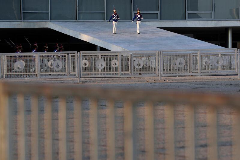 Members of the Presidential Guard march down the ramp of the presidential palace surrounded by barricades ahead of the 11th edition of the BRICS Summit, in Brasilia, Brazil. AP Photo