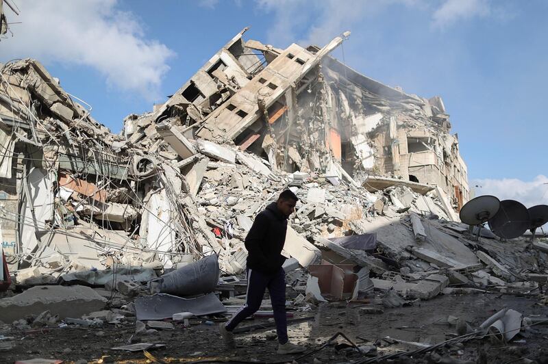 A Palestinian man walks past the remains of a tower building which was destroyed by Israeli air strikes in Gaza City. Reuters