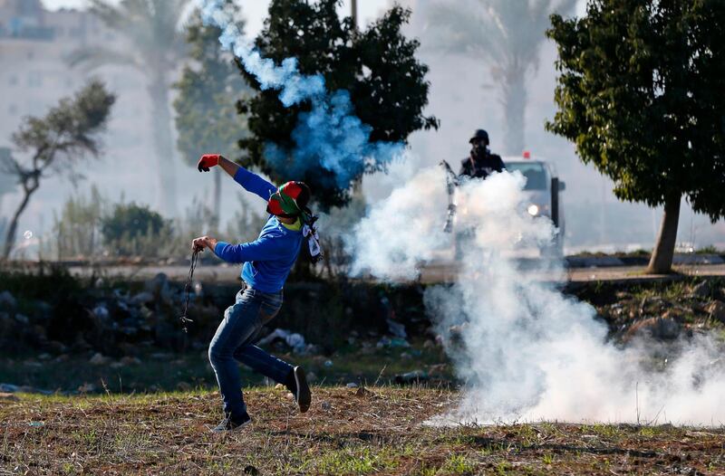 Palestinian protesters clash with Israeli troops near an Israeli checkpoint in the West Bank city of Ramallah on Friday, December 8. Abbas Momani / AFP Photo