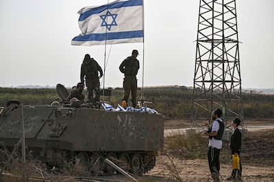 Israeli soldiers on an armoured vehicle speak an ultra-orthodox man, as they deploy near Israel's border with the Gaza Strip. AFP