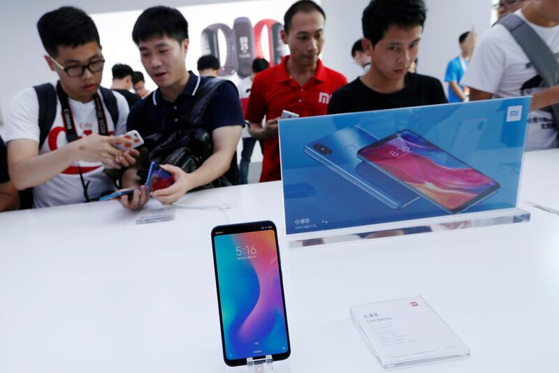 Fans check the new Xiaomi flagship Mi 8 during a product launch in Shenzhen, China May 31, 2018.  REUTERS/Bobby Yip