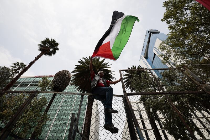 A demonstrator waves a Palestinian flag in front of the headquarters of the US embassy in Mexico City. EPA 