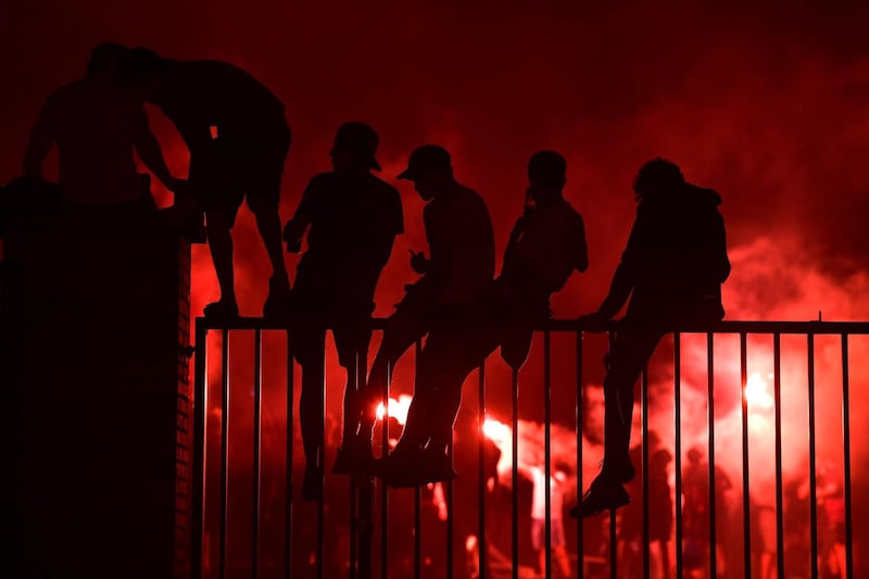 Fans celebrate Liverpool winning the Premier League title outside Anfield stadium. AFP