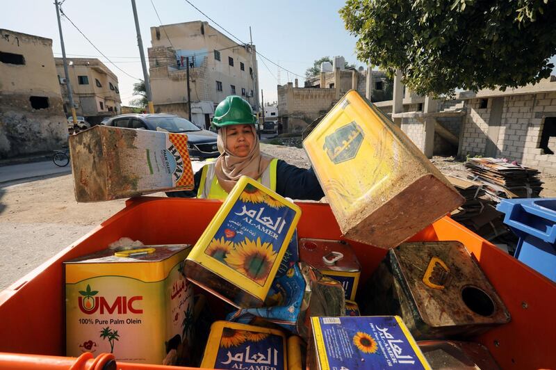 Jordanian woman collects empty metal cans as part of a women-run program to improve Jordan's solid waste management. REUTERS