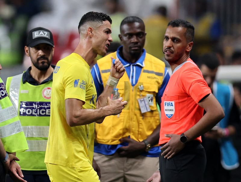 Al Nassr's Cristiano Ronaldo speaks to the fourth official as he leaves the pitch at half-time. Reuters