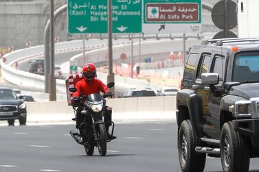 A delivery rider on Dubai's Sheikh Zayed Road. Victor Besa / The National