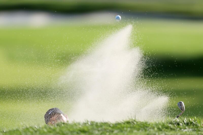 Patrick Reed of the United States plays a shot from a greenside bunker on the second hole. AFP