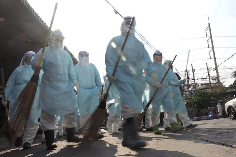 Workers walk through Samut Sakhon Shrimp Center as they disinfect the market in Samut Sakhon, Thailand. AFP