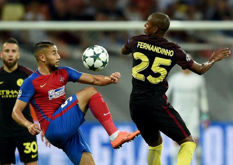 Manchester City's Fernandinho vies for the ball with Steaua Bucharest's Jugurtha Hamroun. (AFP)