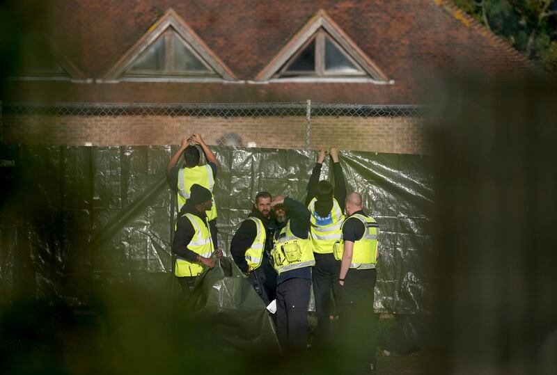 Security staff work to cover the view of people thought to be migrants in the Manston centre. PA