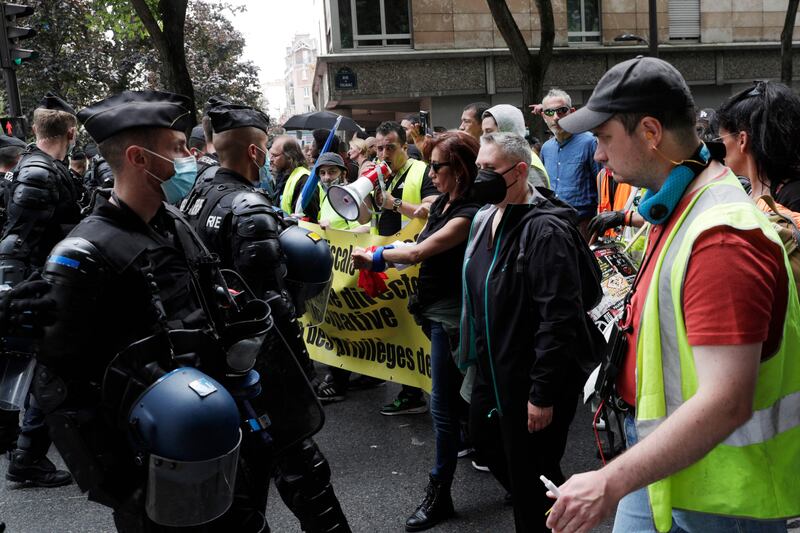 Police confront protesters against the new coronavirus safety measures, in Paris.