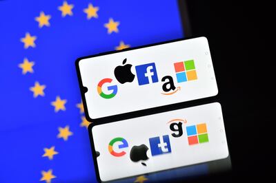 An illustration picture taken in London on December 18, 2020 shows the logos of Google, Apple, Facebook, Amazon and Microsoft displayed on a mobile phone with an EU flag displayed in the background.  The European Union on December 15 unveiled tough draft rules targeting tech giants like Google, Amazon and Facebook, whose power Brussels sees as a threat to competition and even democracy. / AFP / JUSTIN TALLIS
