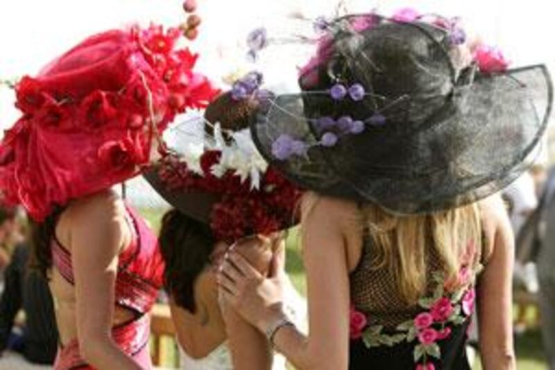 Three women wear colourful hat creations at last year's Dubai World Cup, which took place at the Nad Al Sheba track in Dubai.