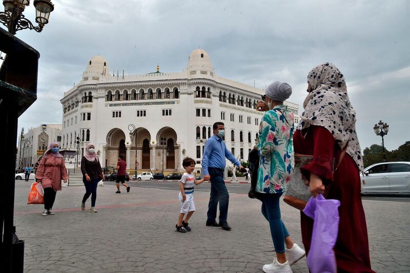 Algerian women walk past the La Grande Poste (main post office) building in the centre of the capital Algiers. AFP