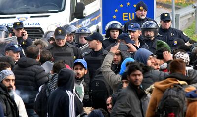 A group of approximately 100 Asian migrants face a police blockade, in the vicinity of Maljevac border crossing near Northern-Bosnian town of Velika Kladusa, on October 24, 2018. Illegal migrants gathered near the border crossing in an attempt to cross into neighboring Croatia. Officers of Bosnian border police and Croatian police prevented the migrans from crossing the border line between the two countries. Numbers of migrants who are passing through Bosnia during the past few months on their way towards the European Union, is on a constant raise. Migrants stop in Sarajevo where they rest before continuing their journey towards North-Western Bosnia and Croatian border. Until recently, Bosnia and its mountainous terrain were avoided by migrants travelling from northern Africa, Middle East or Asia, who, despite the closure of EU borders in March 2016, continued to pass through the Balkans. But, since late 2017 Bosnia is facing the passage of thousands of migrants, who are now stranded.  / AFP / ELVIS BARUKCIC
