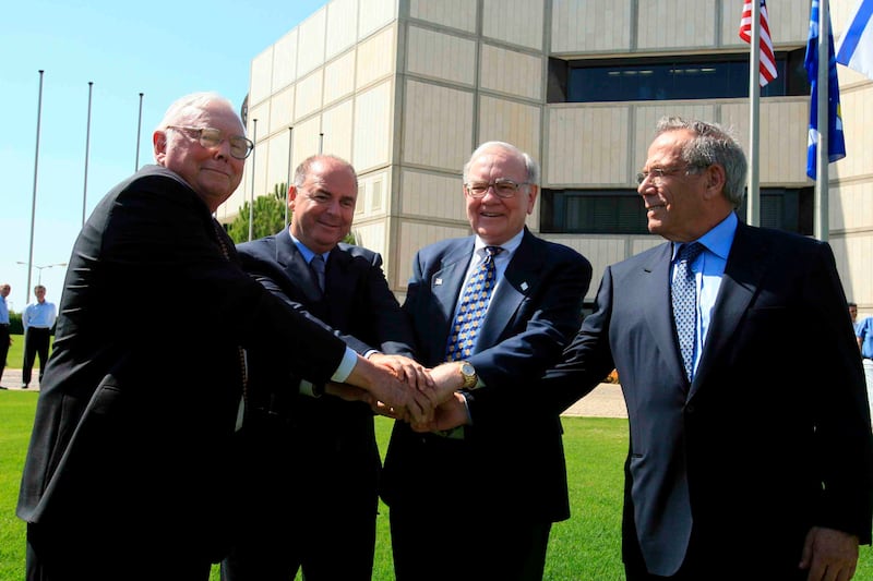 Munger and Warren Buffett shake hands with Eitan and Steff Werthheimer at Iscar Metalworking's headquarters in Israel in September 2006. EPA
