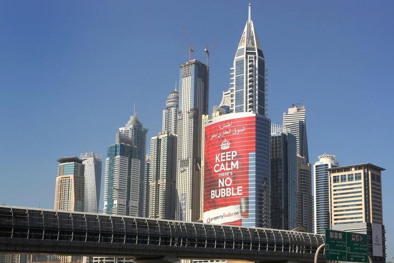 Prices in Dubai’s property market grew by as much as 40 per cent last year. Above, a tower with a sign that reads Keep Calm, No Bubble at the Marina district. Kamran Jebreili / AP Photo