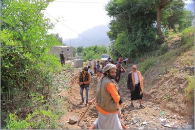 Paid workers and volunteers build a road through the steep mountains of Al Amarnah in Yemen's Ibb governorate. Samah Emlaak
