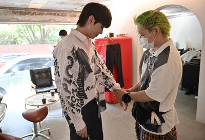 This picture taken on April 29, 2021 shows K-pop boy band Blitzers member Choi Jin-hwa (L) checking his clothing at a beauty salon in Seoul ahead of a promotional shoot. Thirty teenagers, thousands of hours of training, dozens of shattered dreams: it all comes to a head next week when the Blitzers will be launched into the cut-throat K-pop market, hoping to become the next BTS. - TO GO WITH SKorea-music-social-entertainment-Kpop,FOCUS by Kang Jin-kyu
 / AFP / Jung Yeon-je / TO GO WITH SKorea-music-social-entertainment-Kpop,FOCUS by Kang Jin-kyu
