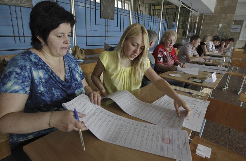 Members of the Election Commission prepare before voting starts at a polling station in Dnipropetrovsk. Ukrainians are widely expected to give a resounding endorsement to the overthrow of their last elected leader by voting on Sunday for presidential candidates promising close ties with the West, in defiance of Russia’s Vladimir Putin. Valentyn Ogirenko/Reuters