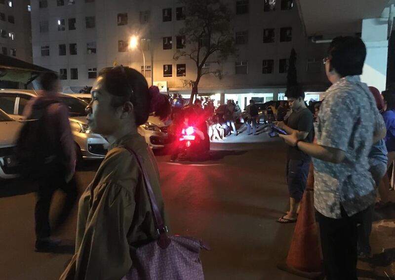 Resident stand outside an apartment block.  AFP