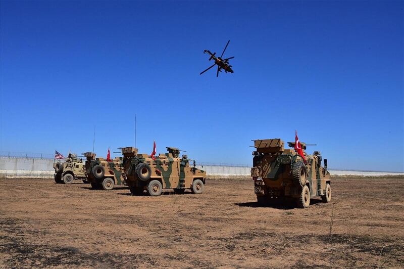 A handout photo made available by Turkey's defence ministry shows Turkish and US army vehicles in Tal Abyad city, at the Turkey-Syria border in northeast Syria.  EPA