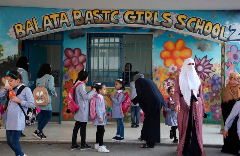 Pupils and teachers gather in front of a school in Balata refugee camp. AFP