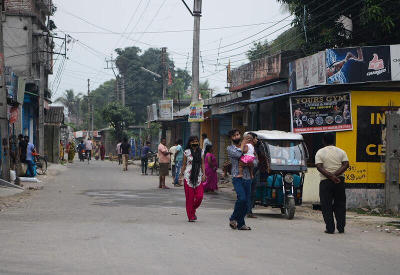 People walk along a street of a residential area during a government-imposed nationwide lockdown as a preventive measure against the Covid-19 coronavirus, in Siliguri.  AFP