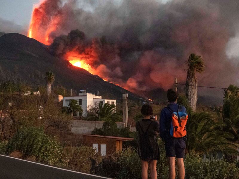 People watch on as the Cumbre Vieja Volcano continues spitting lava. EPA