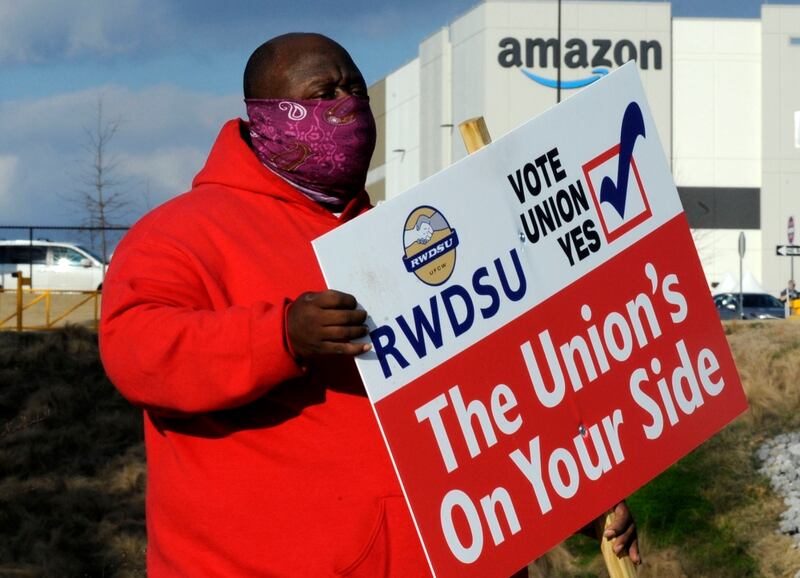 Michael Foster of the Retail, Wholesale and Department Store Union holds a sign outside an Amazon facility before the unionisation vote last year. AP